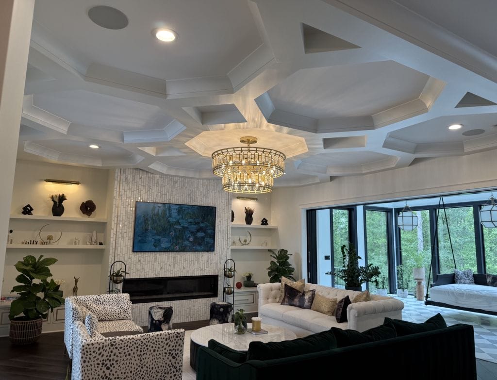 Living room with an octagonal coffered ceiling, crown moldings, built-in shelving beside the fireplace and a gold chandelier