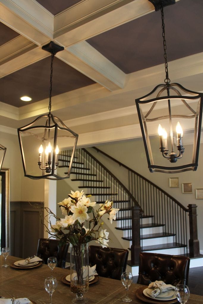 Staircase with iron railing beneath a coffered ceiling by Heavin Trim Carpenters